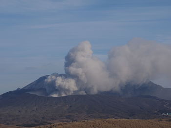 Smoke emitting from volcanic mountain against sky