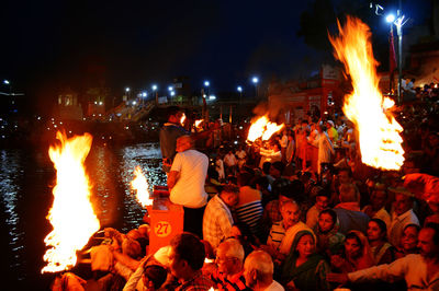 Crowd at illuminated city against sky at night