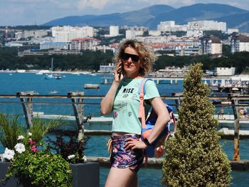 Portrait of young woman standing against sea