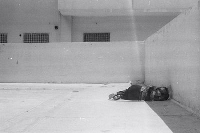 Shadow of man sleeping on footpath against building