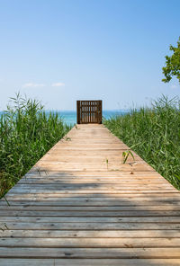 Boardwalk on pier against clear sky