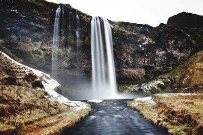 Scenic view of waterfall against sky