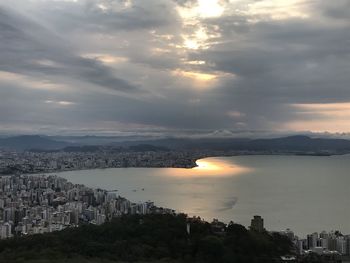 High angle view of city by sea against sky