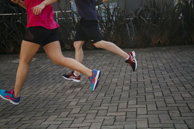 Low section of women running on street