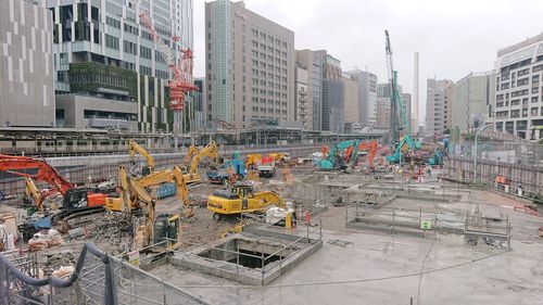 Construction site by buildings against sky in city