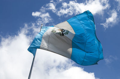 Low angle view of guatemalan flag waving against sky