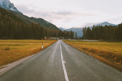 Road amidst green landscape against sky