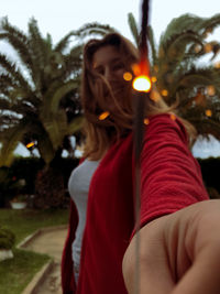 Portrait of young woman with plants in park
