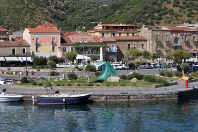 Boats moored in river by townscape