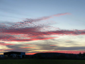 Scenic view of silhouette field against sky during sunset