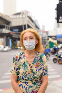 Portrait of woman standing on street in city