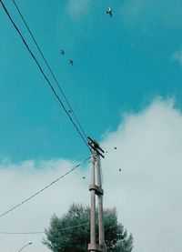 Low angle view of telephone pole against sky