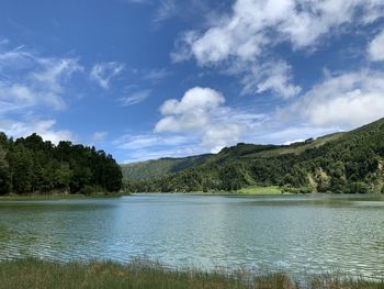 Scenic view of lake by trees against sky