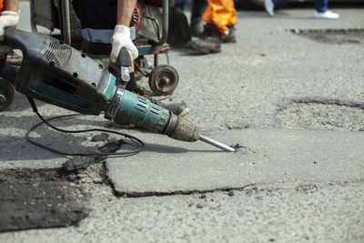 He removes the asphalt with a jackhammer. removing the asphalt layer from the road. 