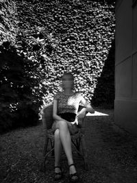 Blurred motion of obscured face young woman sitting on chair