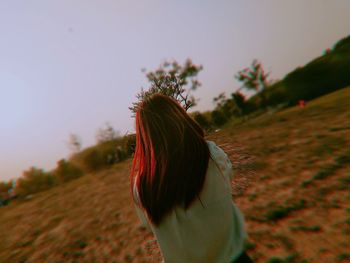 Side view of woman standing on field against sky