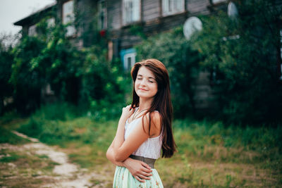 Side view of young woman with eyes closed standing in yard