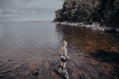 Rear view of boy standing on beach