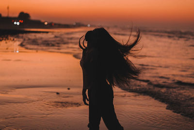 Silhouette woman on beach during sunset