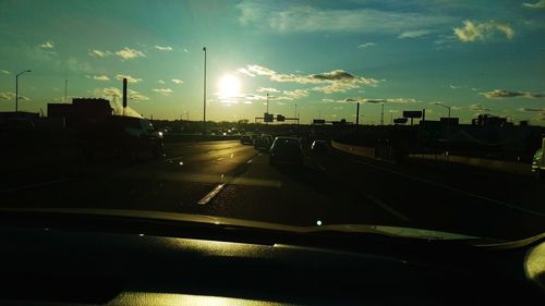 Sun shining through clouds over road