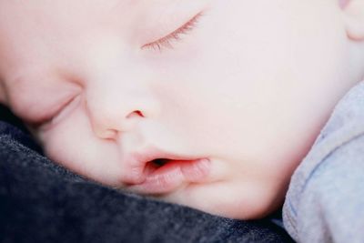 Close-up of cute baby sleeping on bed