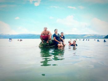 People enjoying in sea against sky