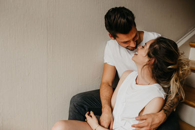 Young couple kissing against wall