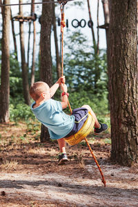 Full length of boy on swing in playground