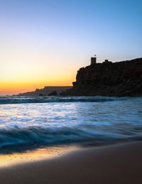 Scenic view of sea against clear sky during sunset