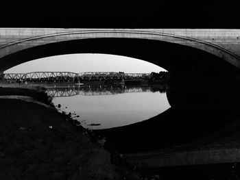 Reflection of bridge in water against sky