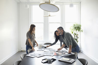 Business people examining photograph printouts in conference room