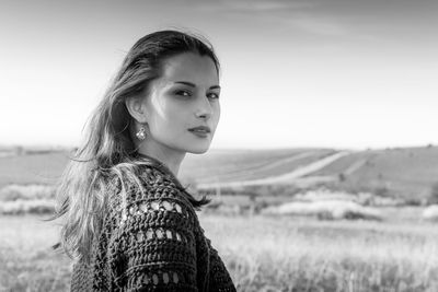 Portrait of woman standing on field against sky