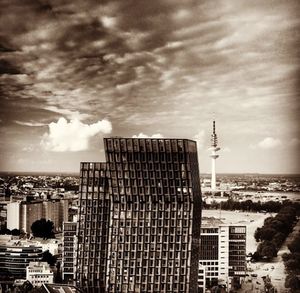 View of cityscape against cloudy sky