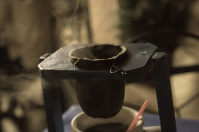 Close-up of strainer over coffee