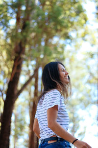 Low angle view of young woman in forest