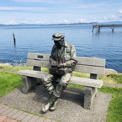 Rear view of people standing at sea shore against sky