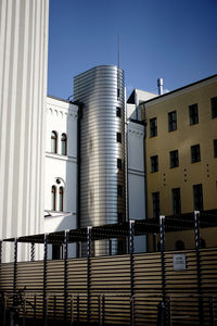 Low angle view of buildings against clear blue sky
