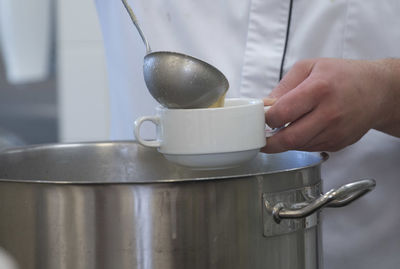 Midsection of man pouring milk
