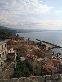 High angle view of townscape by sea against sky