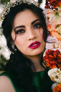 Portrait of woman standing by flowers