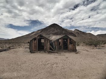 Abandoned house in desert against sky