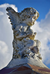 Low angle view of angel statue against sky