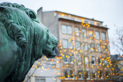 Low angle view of statue against illuminated building