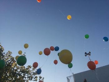 Low angle view of balloons against clear sky