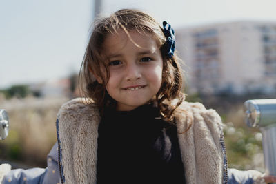 Portrait of a four-year-old girl smiling in a park by day