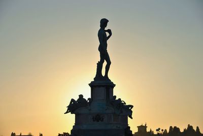 Statue against sky at sunset