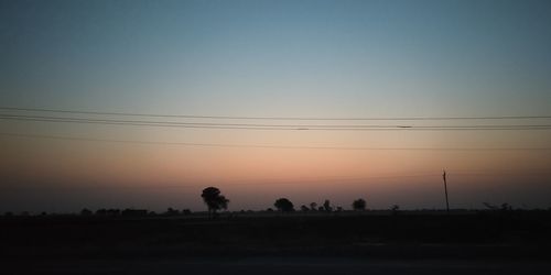 Silhouette landscape against clear sky during sunset