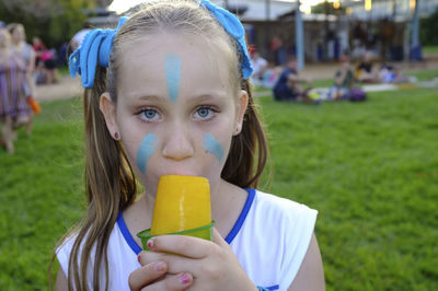 Portrait of boy holding ice cream in park