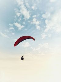 Low angle view of person paragliding against sky