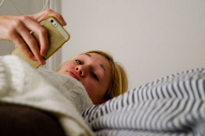 Young woman smiling while relaxing on bed at home